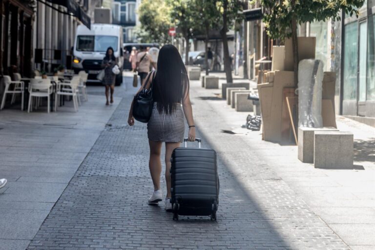 Persona caminando con maleta en una calle de Madrid