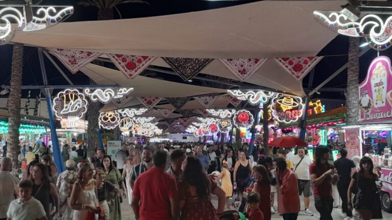 Multitud en la Feria de Melilla con luces y decoraciones festivas