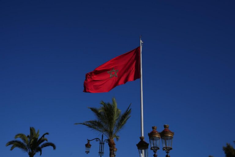 Bandera de Marruecos ondeando bajo un cielo azul claro