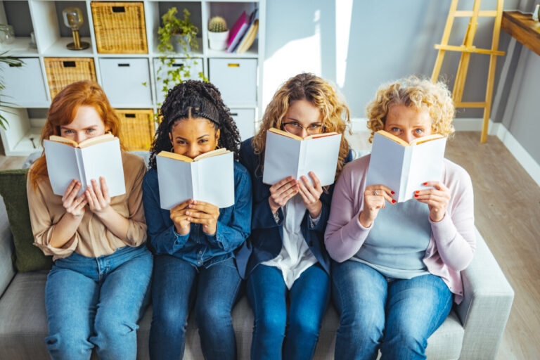 Cuatro mujeres leyendo libros en un ambiente acogedor