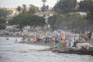 Vista de la playa en Ceuta con migrantes y tiendas improvisadas
