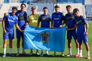 Jugadores de la U.D. Melilla celebrando el Día de Melilla con una bandera