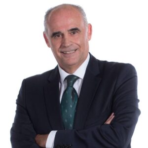 Retrato de Emilio Guerra con fondo blanco y traje oscuro