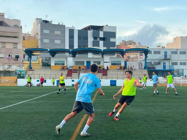 Jugadores entrenando en un campo de fútbol con camisetas de colores