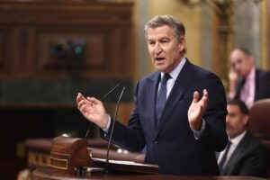 Político hablando en un salón de actos con gestos expresivos
