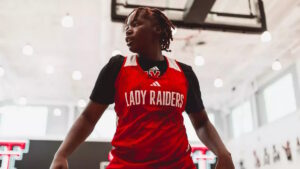 Jugadora de baloncesto con uniforme de Lady Raiders en acción