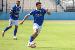 Fran Bueno, lateral de la U.D. Melilla, corriendo con el balón en el campo.