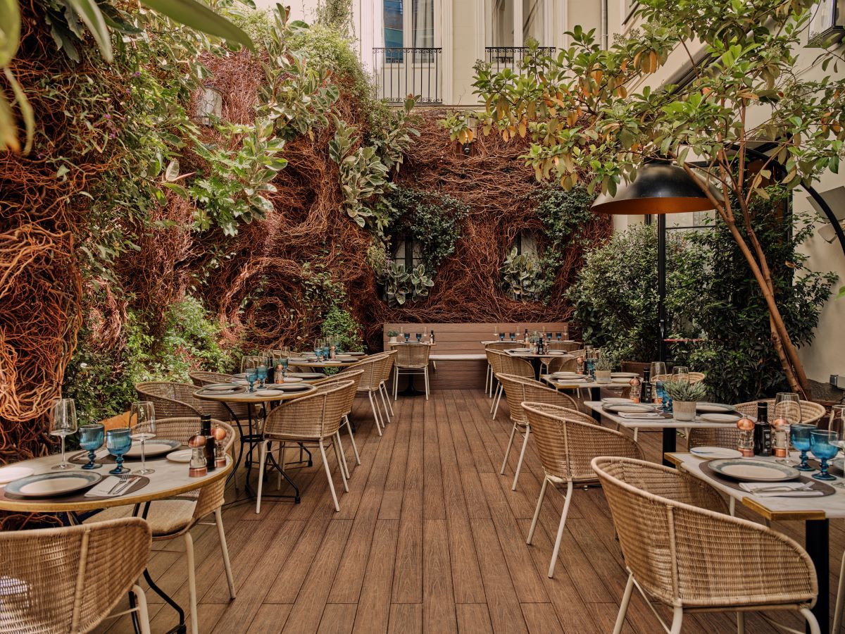 Terraza de un restaurante en Madrid con decoración natural y mesas preparadas