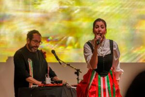 Artista cantando en el Iwa Fest con fondo colorido