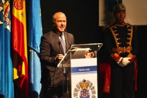 Miguel Marín hablando en un acto de la Policía Local con banderas de fondo