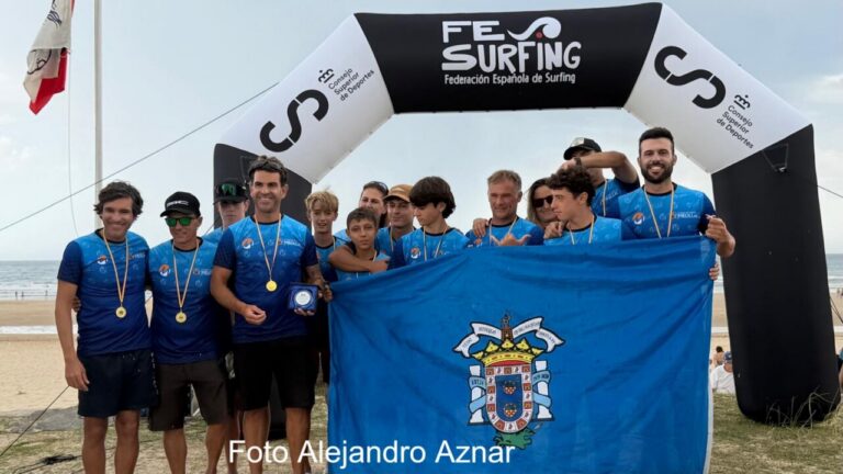 Equipo de surf de Melilla posando con medallas y bandera en campeonato