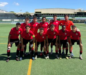 Equipo de fútbol Melilla City C.F. en uniforme rojo posando en el campo