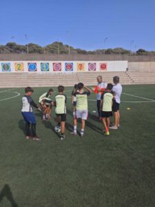 Entrenadores y niños en el campo de fútbol del C.D. Melistar