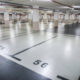 Underground parking garage with empty spaces; foreground shows spots 55 and 56 marked on the light floor.
