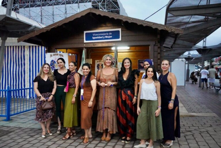 Grupo de mujeres en la Feria de Melilla junto a un punto de información