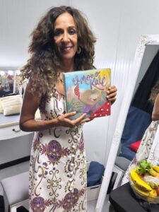 Rosario Flores sosteniendo el libro El mono Kalé de Juan Heredia Urbano