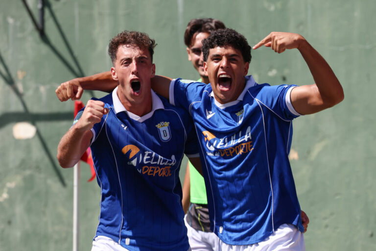 Jugadores de la U.D. Melilla celebrando un gol con alegría en el campo