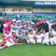 Jugadores de la U.D. Melilla celebrando en el campo con su entrenador