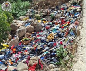 Montón de ropa desechada en el cauce del Río de Oro en Melilla