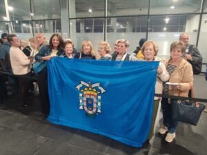 Grupo de mayores sosteniendo una bandera en un viaje a Cádiz