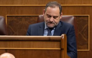 José Luis Ábalos sentado en un escaño de madera, con la mirada baja.