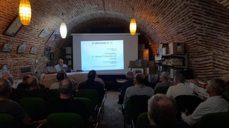 Asistentes observan una proyección sobre Manuel Villacampa en una sala abovedada de ladrillo