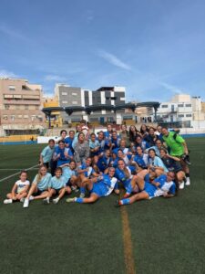 Grupo del ATM Melilla posa en un campo de fútbol con equipaciones azules.