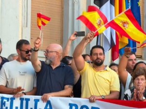 Personas ondeando banderas en un evento en Melilla