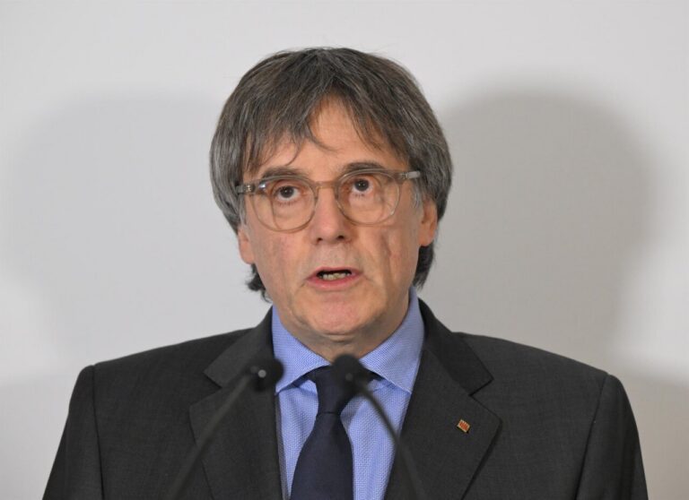 Carles Puigdemont aparece con gafas y traje ante un fondo claro.