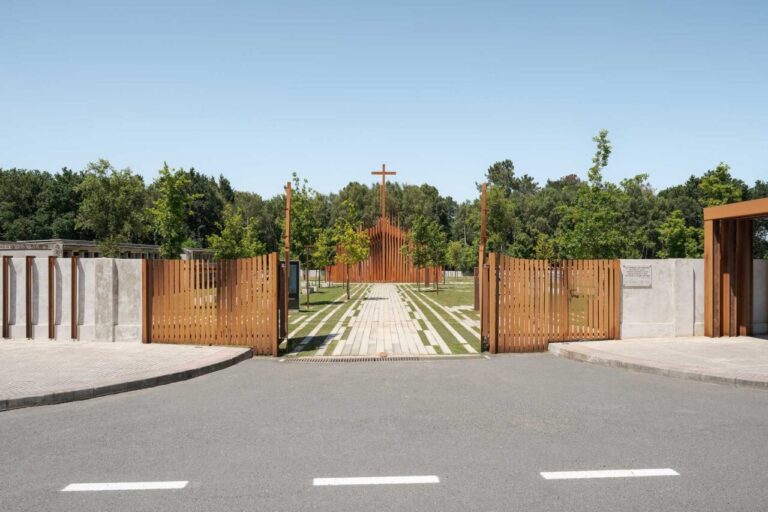 Entrada del cementerio de A Romea, con portón de madera y camino central arbolado