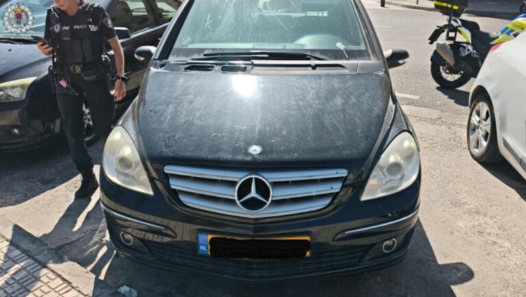 Un coche Mercedes con matrícula neerlandesa aparece junto a un agente de policía.