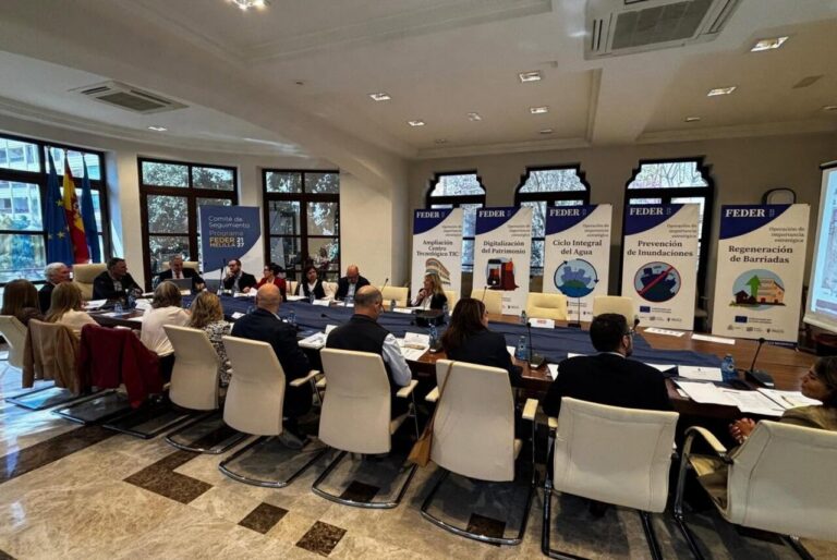 Participantes reunidos alrededor de una mesa en una sesión de seguimiento del programa FEDER.