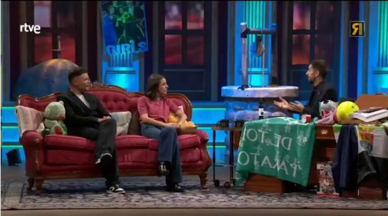 Tres personas conversan en un sofá y una mesa de un plató televisivo.