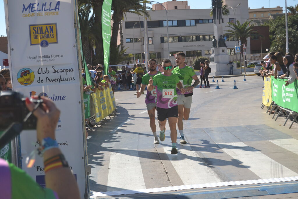 Tres corredores avanzan por el recorrido mientras el público los anima detrás de las vallas.