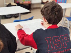 Estudiante en clase revisando un informe educativo
