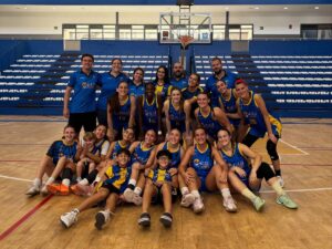 Integrantes del equipo de baloncesto La Salle posan juntos en una cancha cubierta.