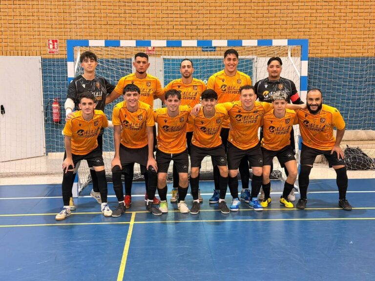 Jugadores de fútbol sala posan en dos filas frente a una portería cubierta.