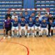 Equipo de fútbol sala posa en la pista frente a la portería del pabellón