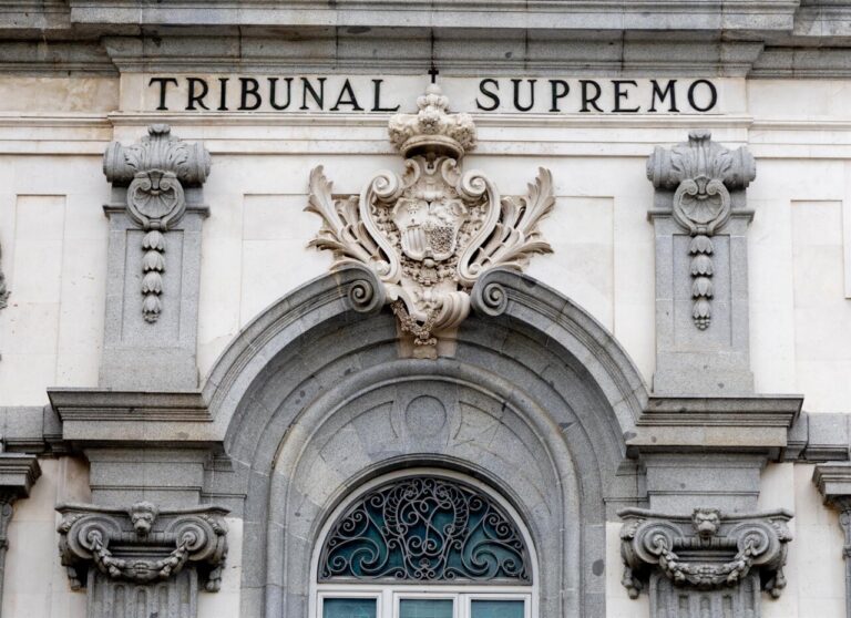 Facade of a historic courthouse with the words TRIBUNAL SUPREMO above an ornate coat of arms and arched doorway