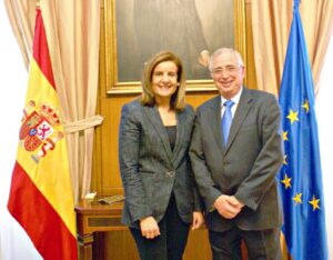 Fátima Báñez y Juan José Imbroda posan juntos ante las banderas española y europea.