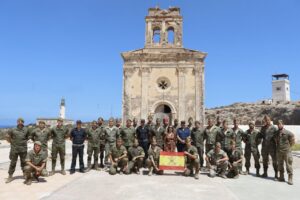 Grupo de personas con ropa de camuflaje posa ante un edificio histórico en Chafarinas.