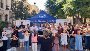 Grupo de personas posa frente a una carpa del Banco de Alimentos de Melilla.