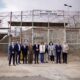 Grupo de diez personas posa frente a una entrada vallada con el rótulo Paso Barrio Chino