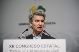 Un hombre habla desde un atril ante dos micrófonos durante un congreso estatal