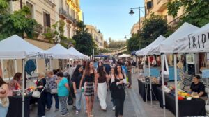 Gente disfrutando de la IV Verbena en Zona Centro con puestos de comida y actividades.