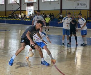 Jugadores disputan un balón durante un partido de balonmano en una cancha cubierta