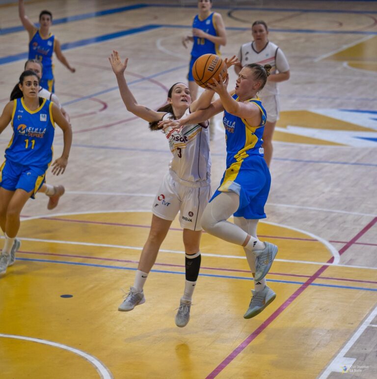Jugadoras de baloncesto compiten en una cancha durante un partido.