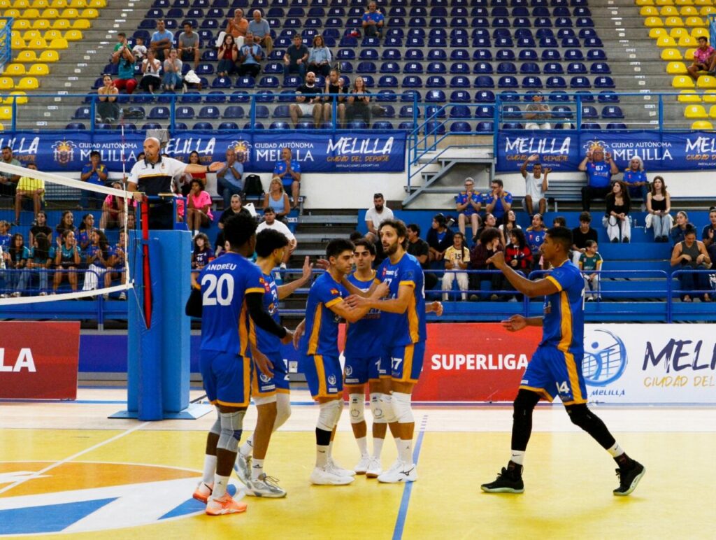 Jugadores del Club Voleibol Melilla se reúnen en la cancha junto a la red.