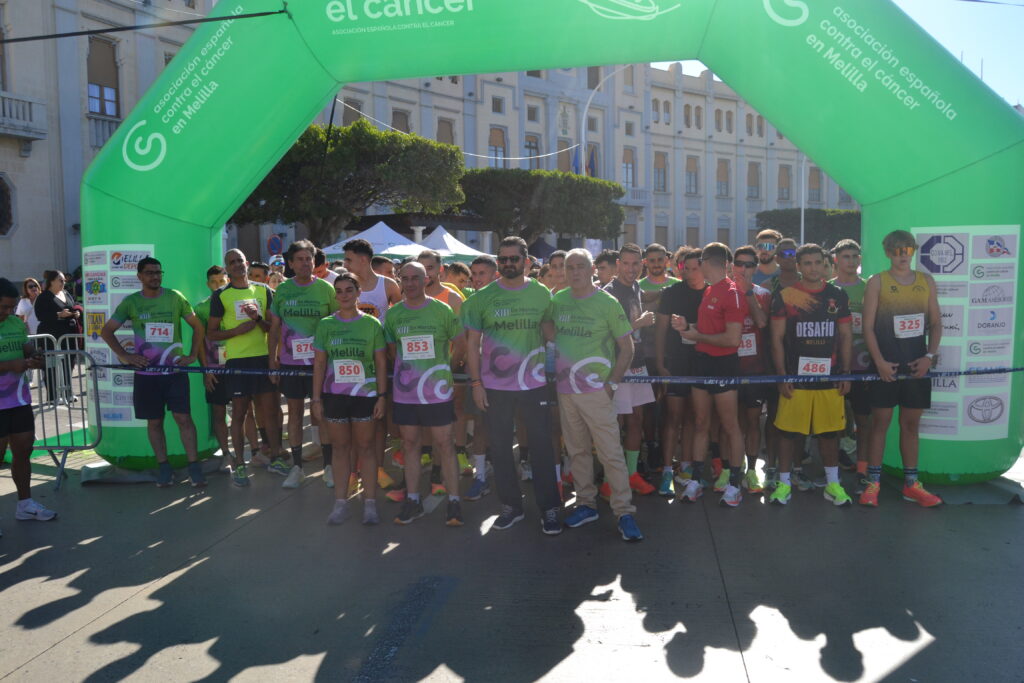 Participantes reunidos bajo el arco verde de la carrera Melilla en Marcha contra el Cáncer