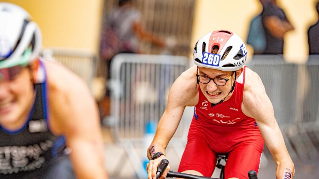 Dos participantes pedalean en un recinto cubierto durante una competición.